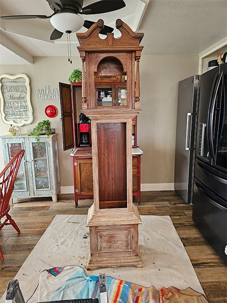 Repurposing Idea: First, you have to know that I don't share closet space well. My closet is in our bedroom, and my husband's closet is in one of the upstairs guest rooms.  (He truly doesn't mind; for which I am thankful.) Inspired by the clock's tall structure, I decided to turn it into a practical wardrobe organizer. By adding hooks on the inside, I could create a designated space to hang clothes that my husband often takes off or needs to wear the next day. This solution eliminated the need to have a shirt or other piece of clothing tossed on a chair and brought a bit more tidiness to our bedroom.